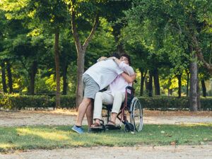 Un joven abraza a otro en silla de ruedas
