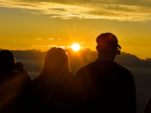 Dos personas observan un atardecer en la montaña