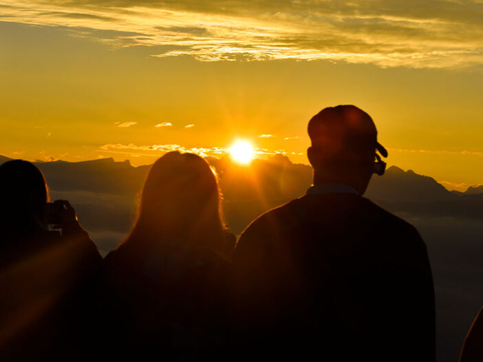 Dos personas observan un atardecer en la montaña