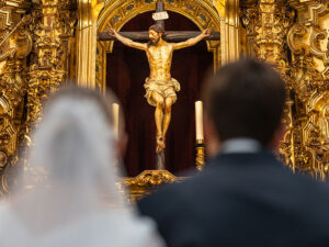 Un matrimonio delante de un crucifijo