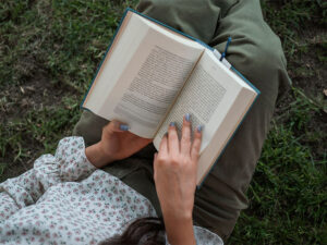 Una chica leyendo un libro en el campo