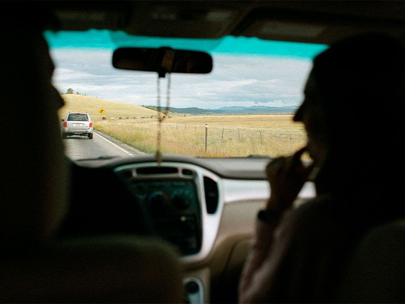 Un rosario cuelga del retrovisor de un coche